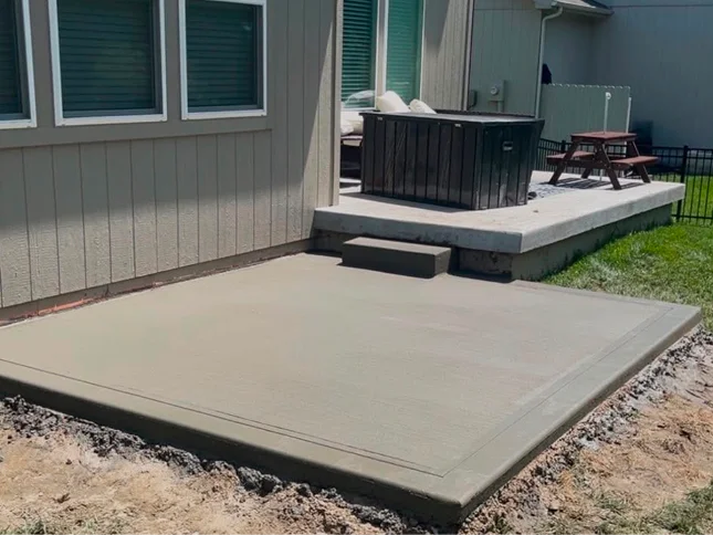 Newly poured concrete driveway leading to a three-car garage