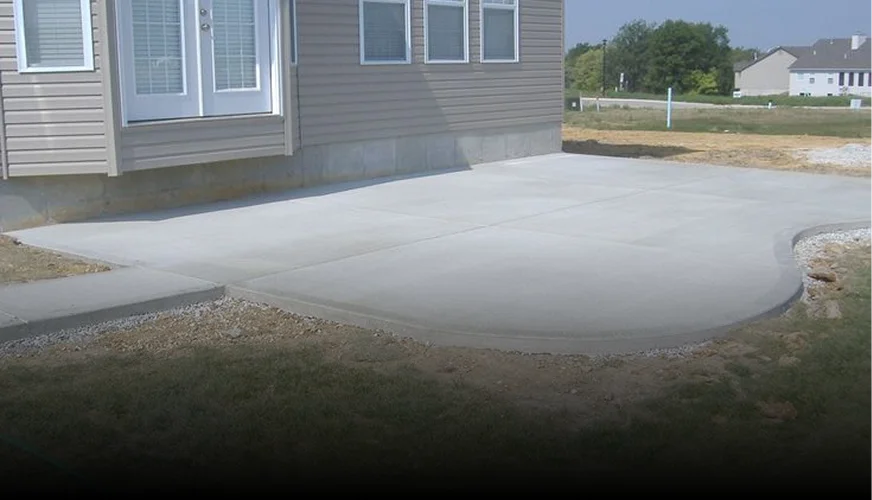 Wide concrete driveway apron sweeping out to a tree-lined street