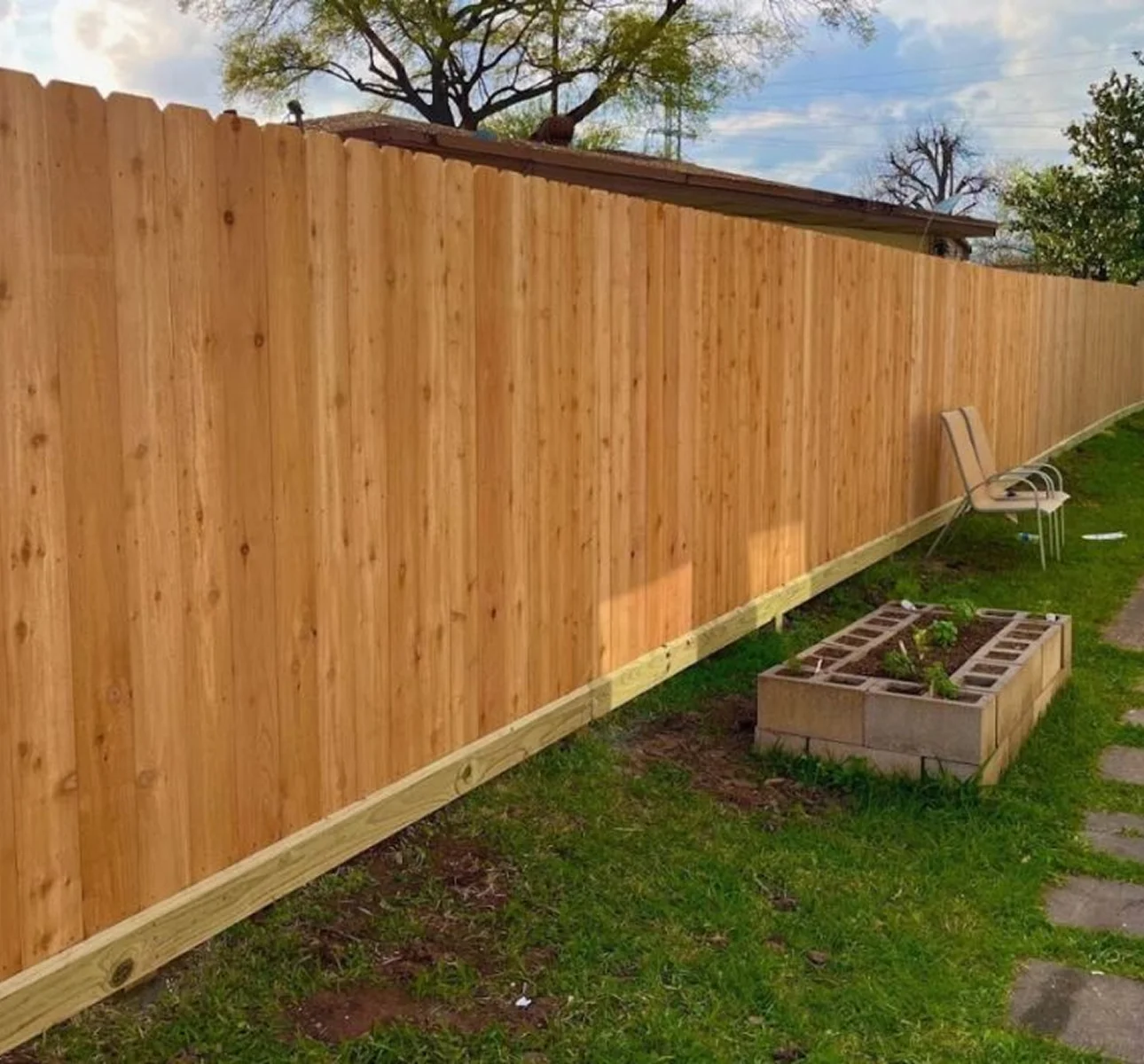Tall vertical board privacy fence and matching gate along a side yard