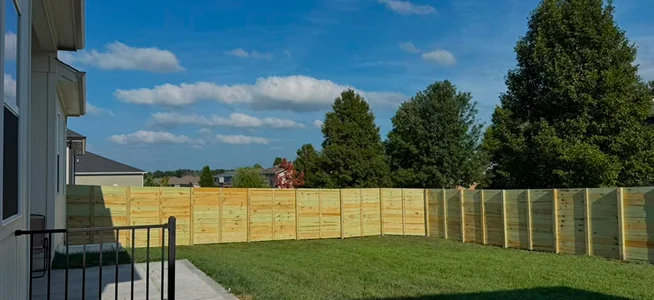 Black horizontal panel privacy fence along a walkway